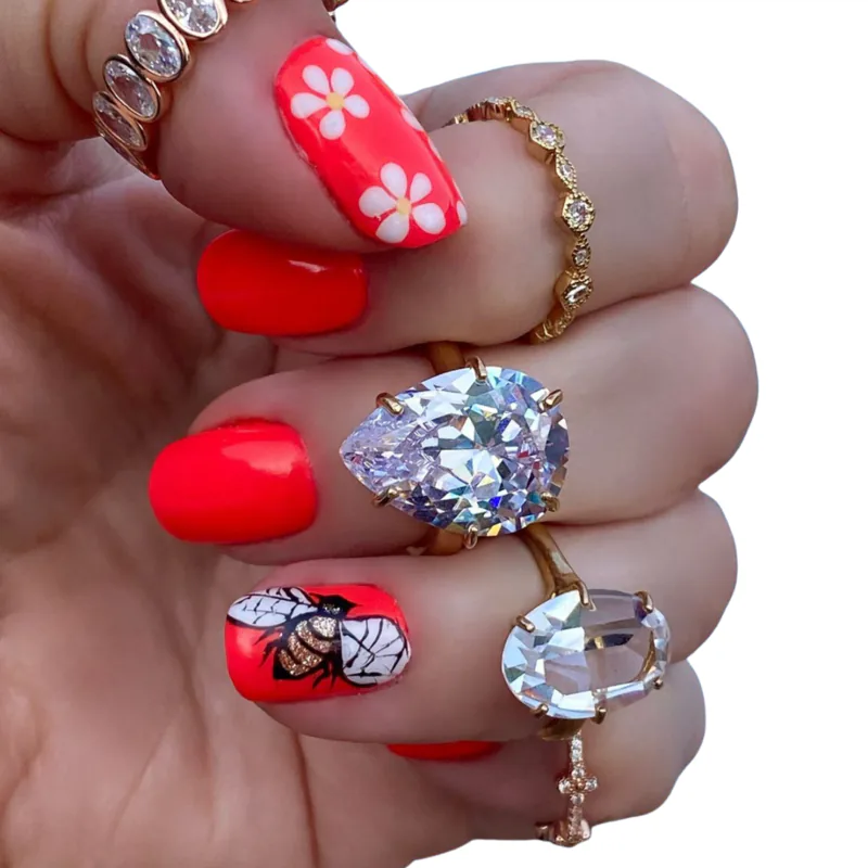 red nails with flower and bee nail art